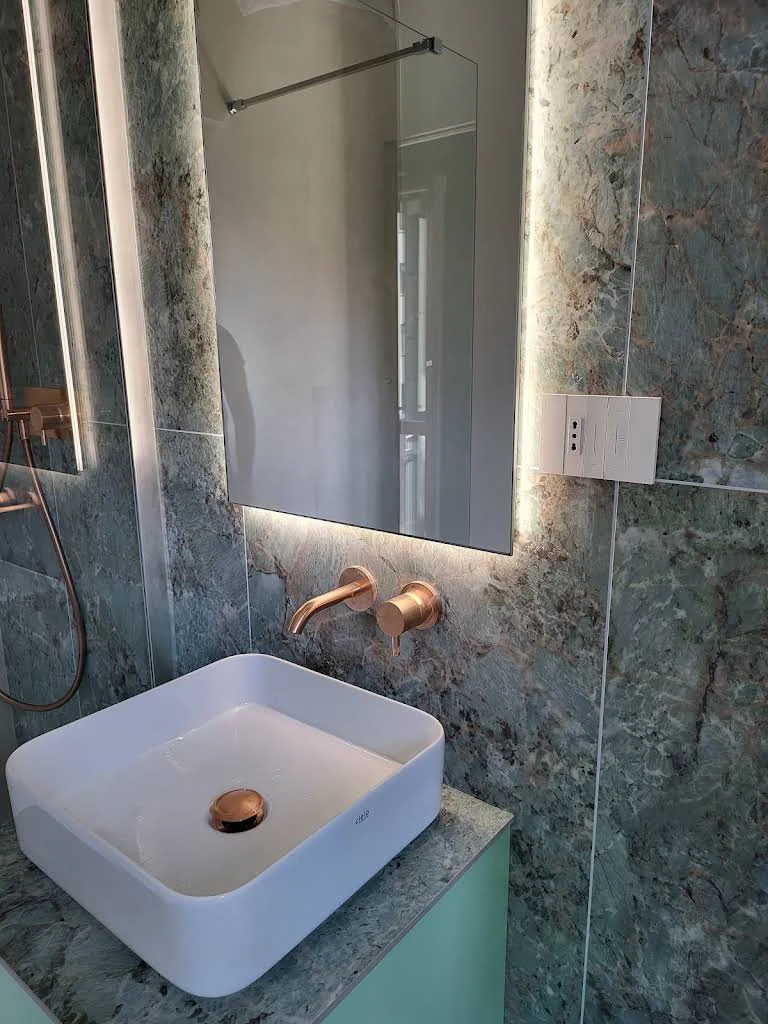 Lavabo con specchio illuminato e rivestimento scuro